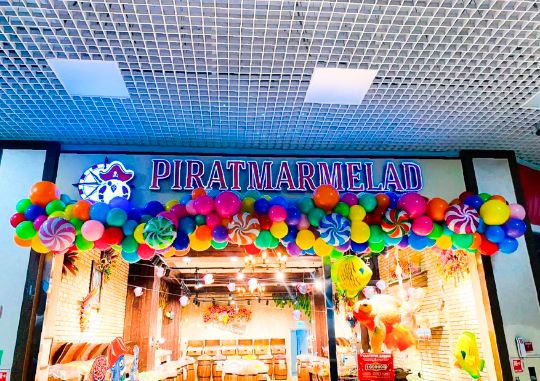 ⚓ Оформление входной группы магазина «PIRATMARMELAD» разноразмерной гирляндой с элементами фольгированных шаров «Леденец».
